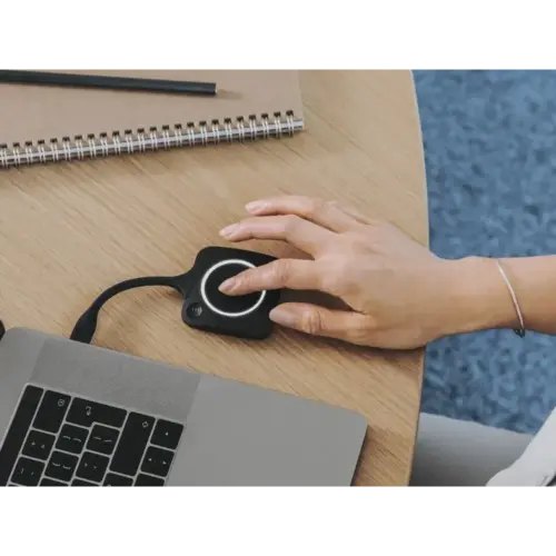 Vrouw gebruikt presentatieknop met laptop en notitieboek